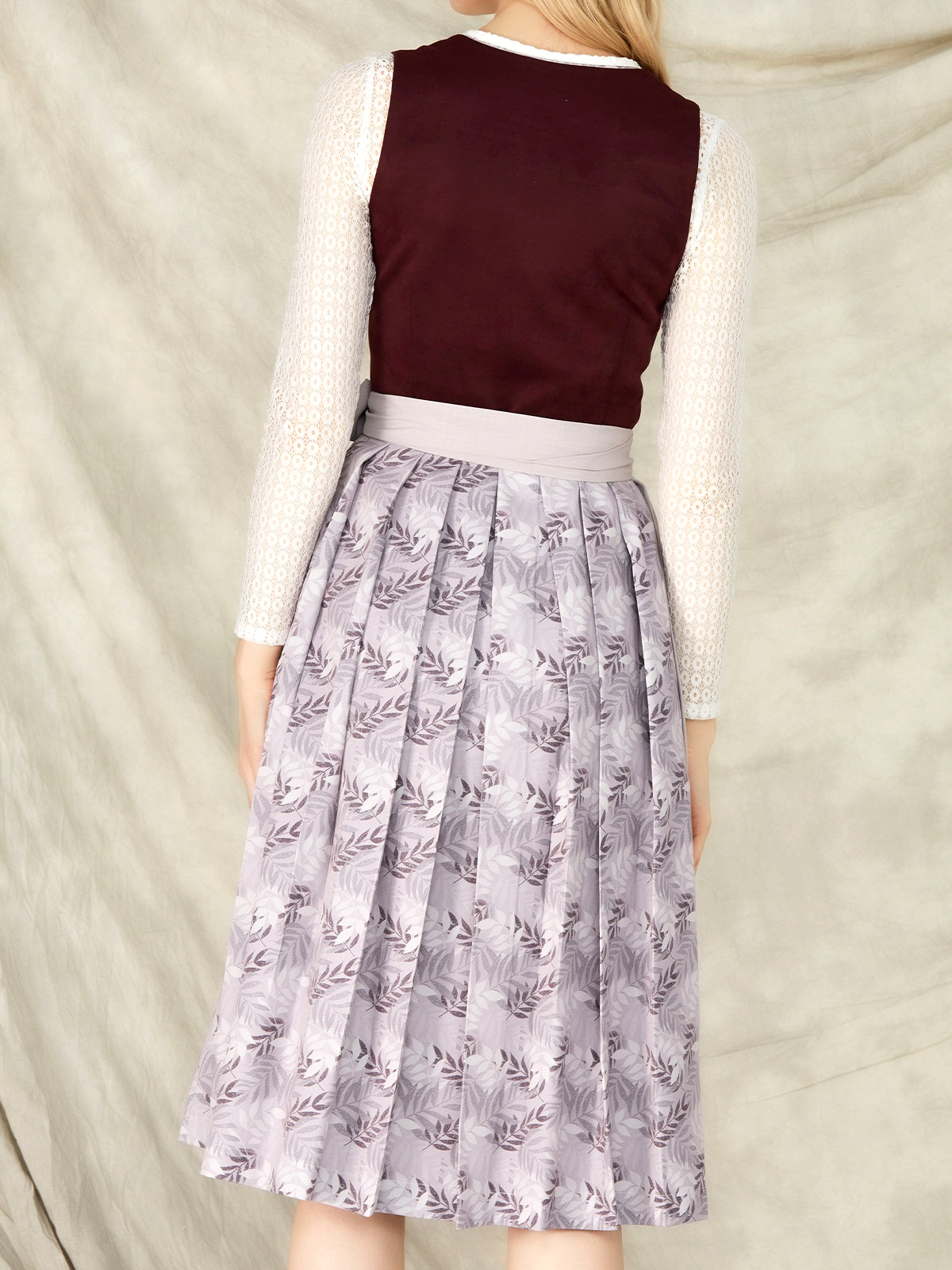 Weisser Spitzenbody unter einem lila Dirndl